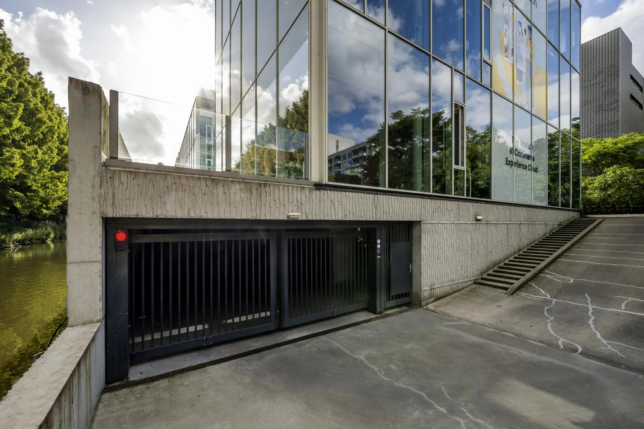 Ingang van een ondergrondse parkeergarage aan de Fred. Roeskestraat naast een modern kantoorgebouw met glazen gevel.